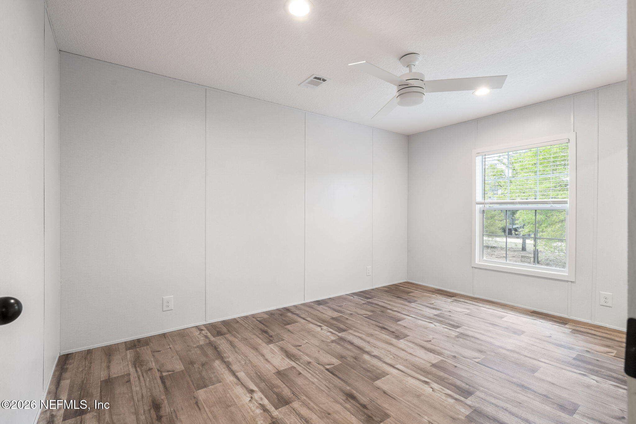 110 Slipper Way Hawthorne, FL 32640 - Photo 27 of 42 an empty room with wooden floor fan and windows