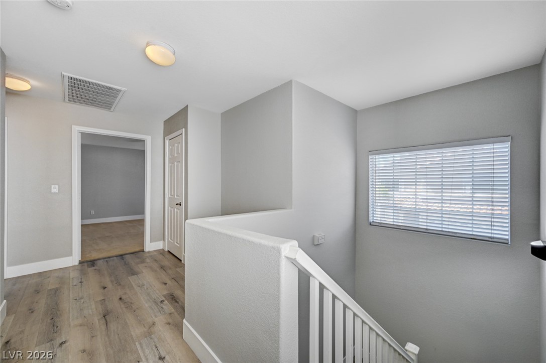 7259 Cestrum Road Las Vegas, NV 89113 - Photo 13 of 35 A well-lit landing area showcases resilient flooring and a clear pathway to upper-level spaces.