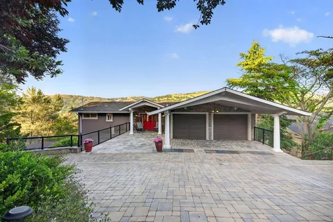 a view of a house with a patio and a yard