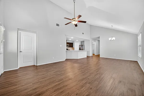 a view of a kitchen with wooden floor and a ceiling fan