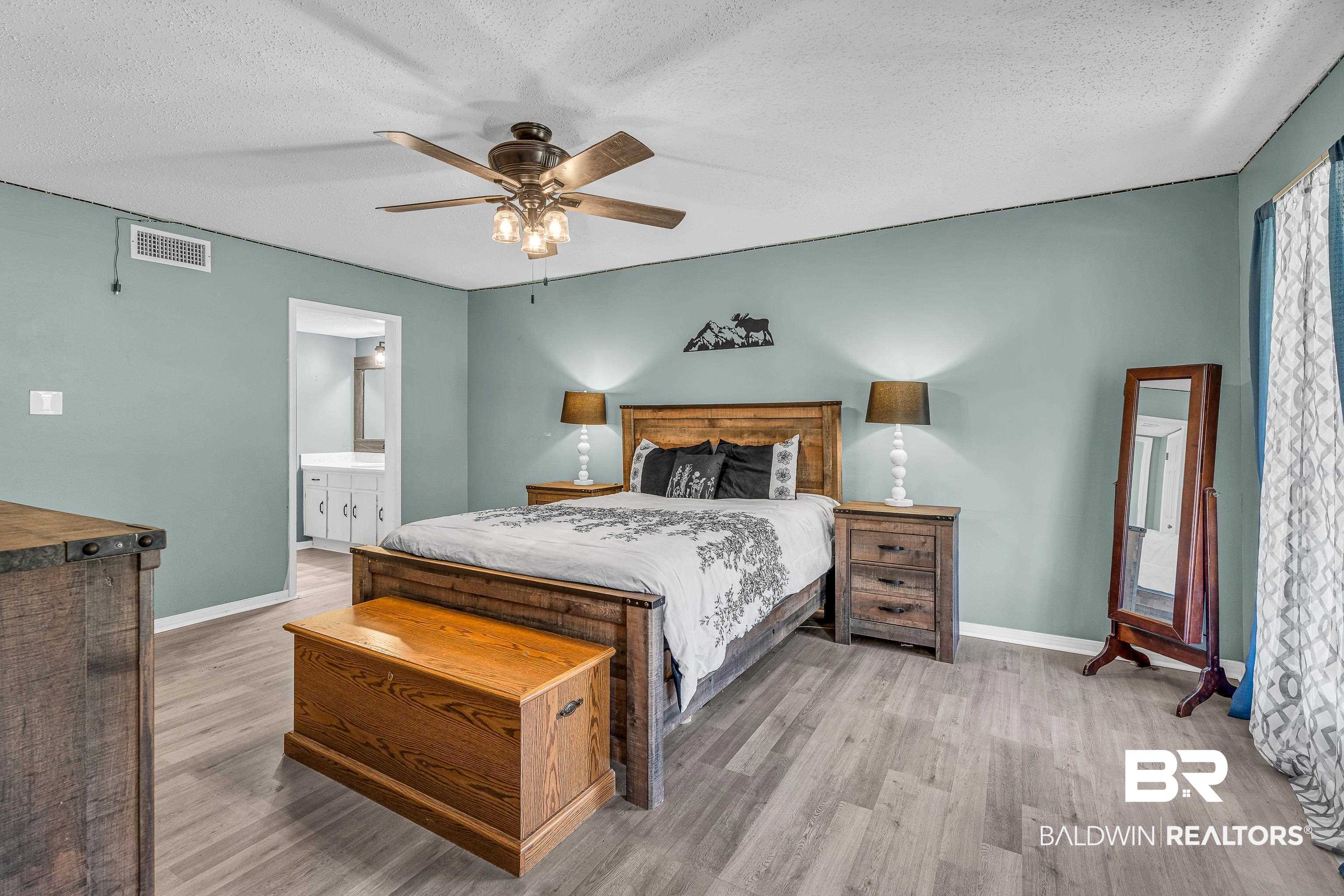 6135 Oak Cliff Drive Eight Mile, AL 36613 - Photo 17 of 30 Bedroom featuring a textured ceiling, light wood-type flooring, ceiling fan, and ensuite bath