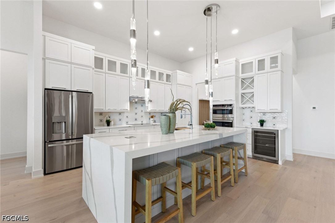 1524 Southwest 57th Street Cape Coral, FL 33914 - Photo 11 of 45 a kitchen with stainless steel appliances kitchen island granite countertop a refrigerator a oven a sink and white cabinets with wooden floor