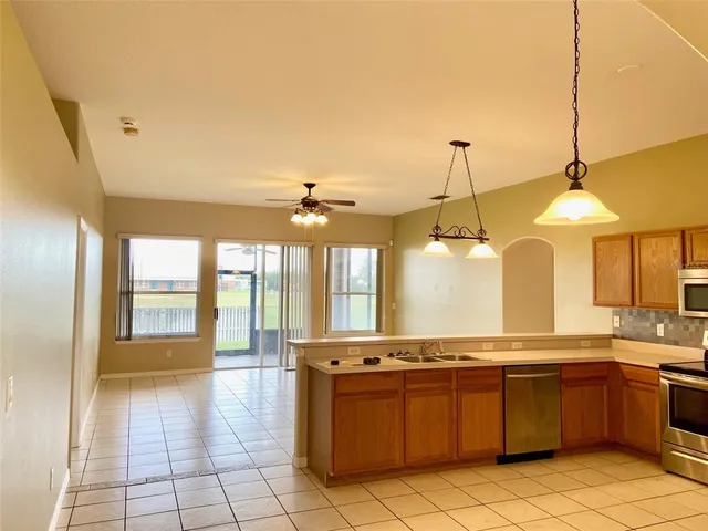 a large kitchen with granite countertop a stove a sink and a wooden floors