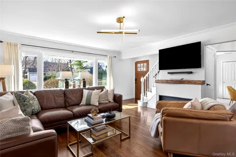 a living room with furniture a flat screen tv and a large window