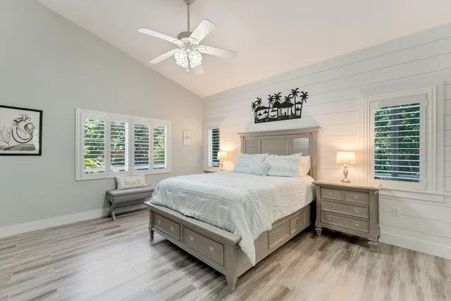 a bedroom with a large bed chandelier and a window