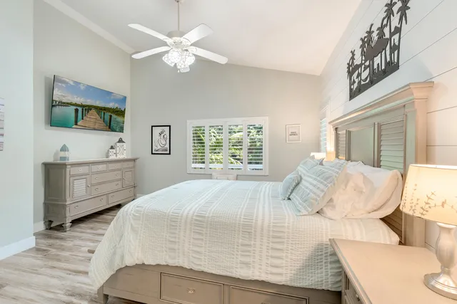 a bedroom with a bed a dresser and flat screen tv