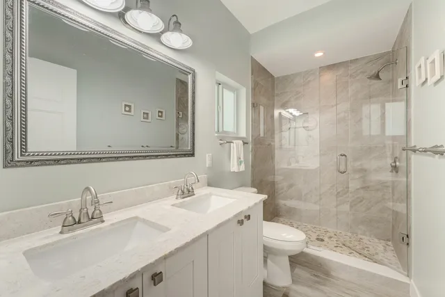 a bathroom with a sink a toilet and shower