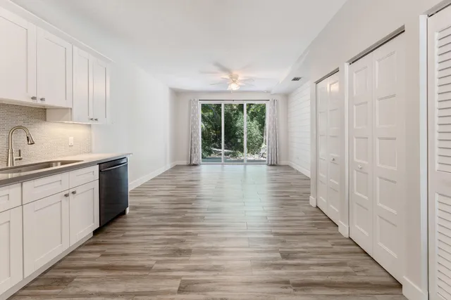 a hallway with wooden floors and white walls