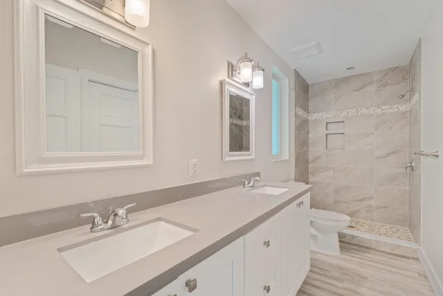 a bathroom with a sink a toilet and shower