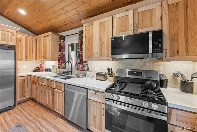 a kitchen with stainless steel appliances a stove microwave and sink