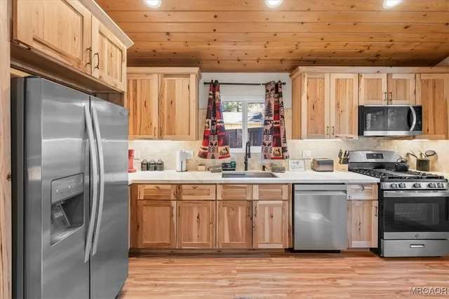 a kitchen with stainless steel appliances granite countertop a refrigerator a stove and a sink