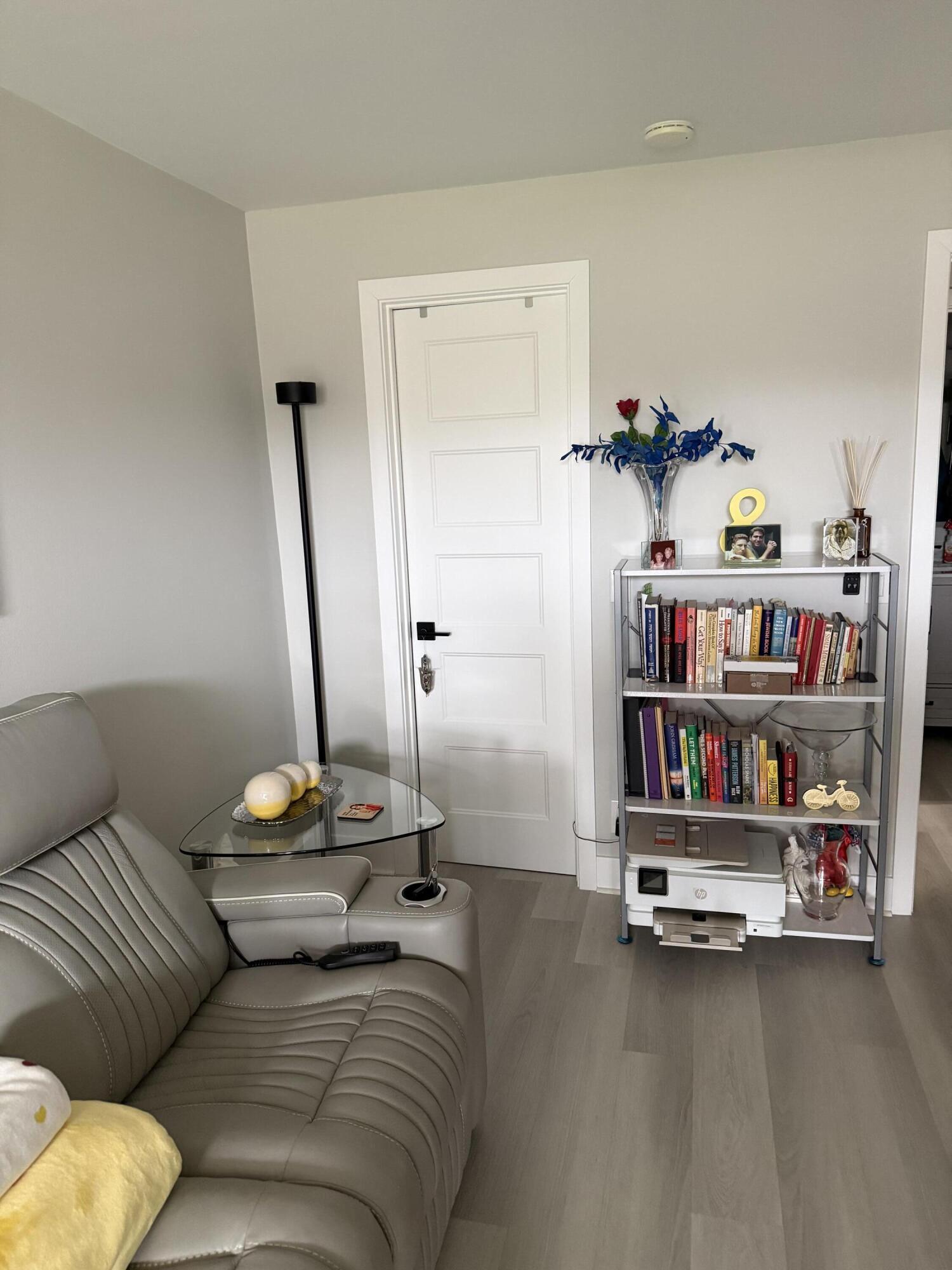 1066 Ainslie Drive, Unit 1066 Boca Raton, FL 33434 - Photo 17 of 28 a living room with furniture cabinets and a book shelf