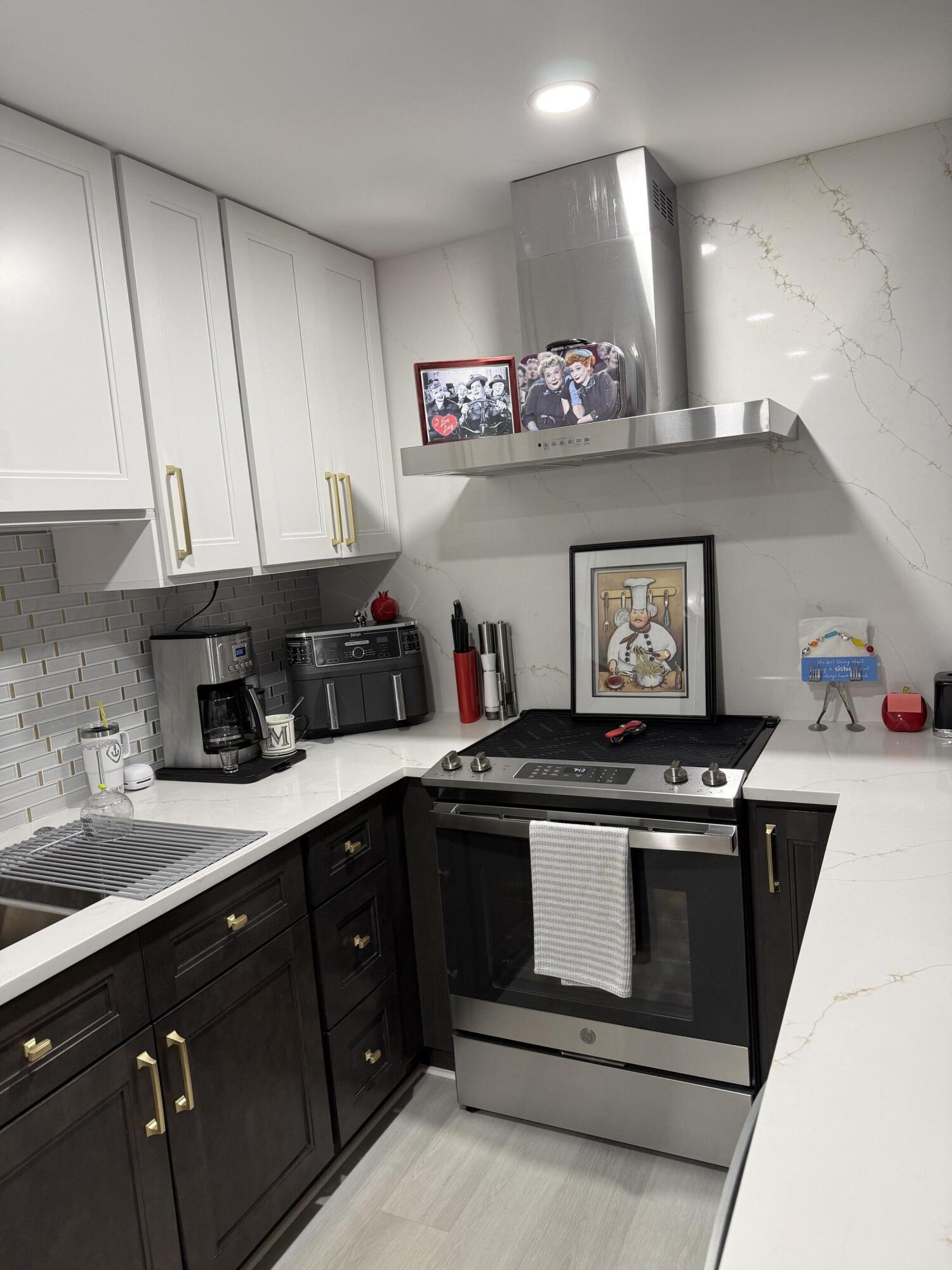 1066 Ainslie Drive, Unit 1066 Boca Raton, FL 33434 - Photo 2 of 28 a kitchen with stainless steel appliances granite countertop a stove and a sink