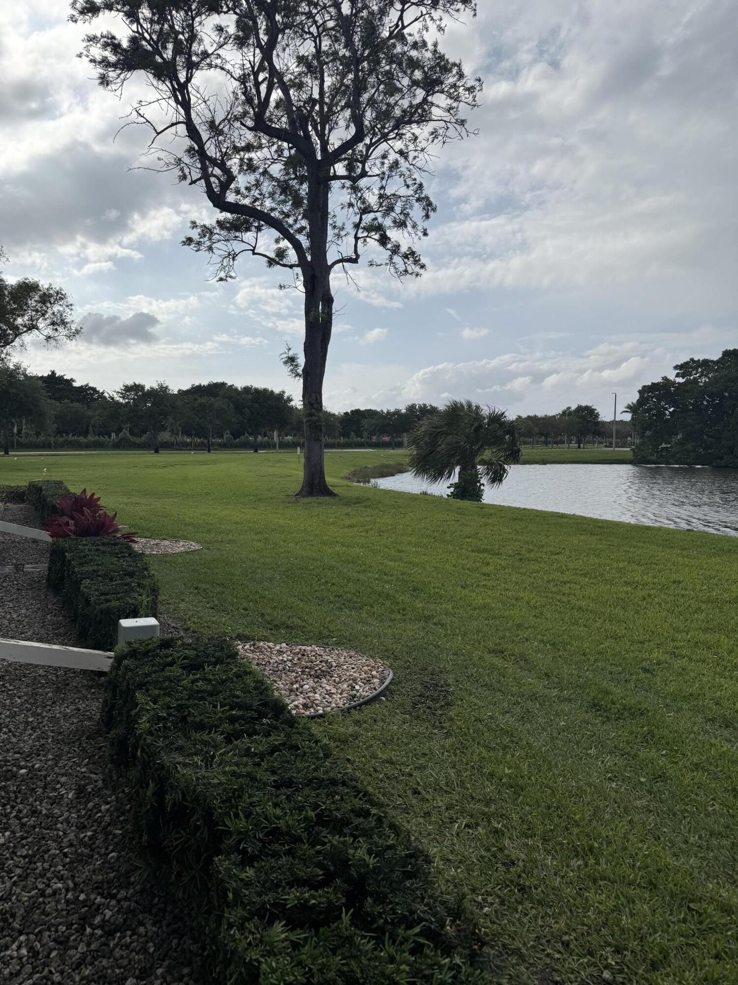 1066 Ainslie Drive, Unit 1066 Boca Raton, FL 33434 - Photo 22 of 28 a view of a lake with a yard