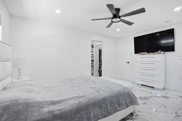 a bedroom with a bed and a flat screen tv