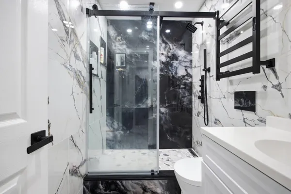 a bathroom with a sink a toilet and shower