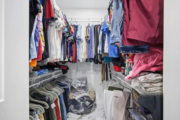 a view of walk in closet with clothes