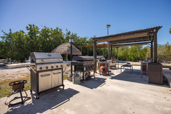 a view of a patio with a table chairs and a barbeque