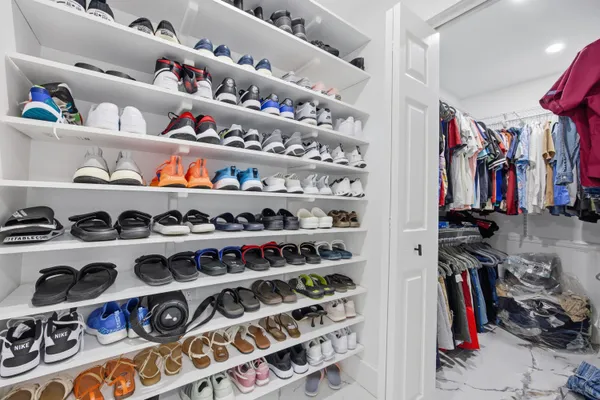 a view of walk in closet with clothes and shoes