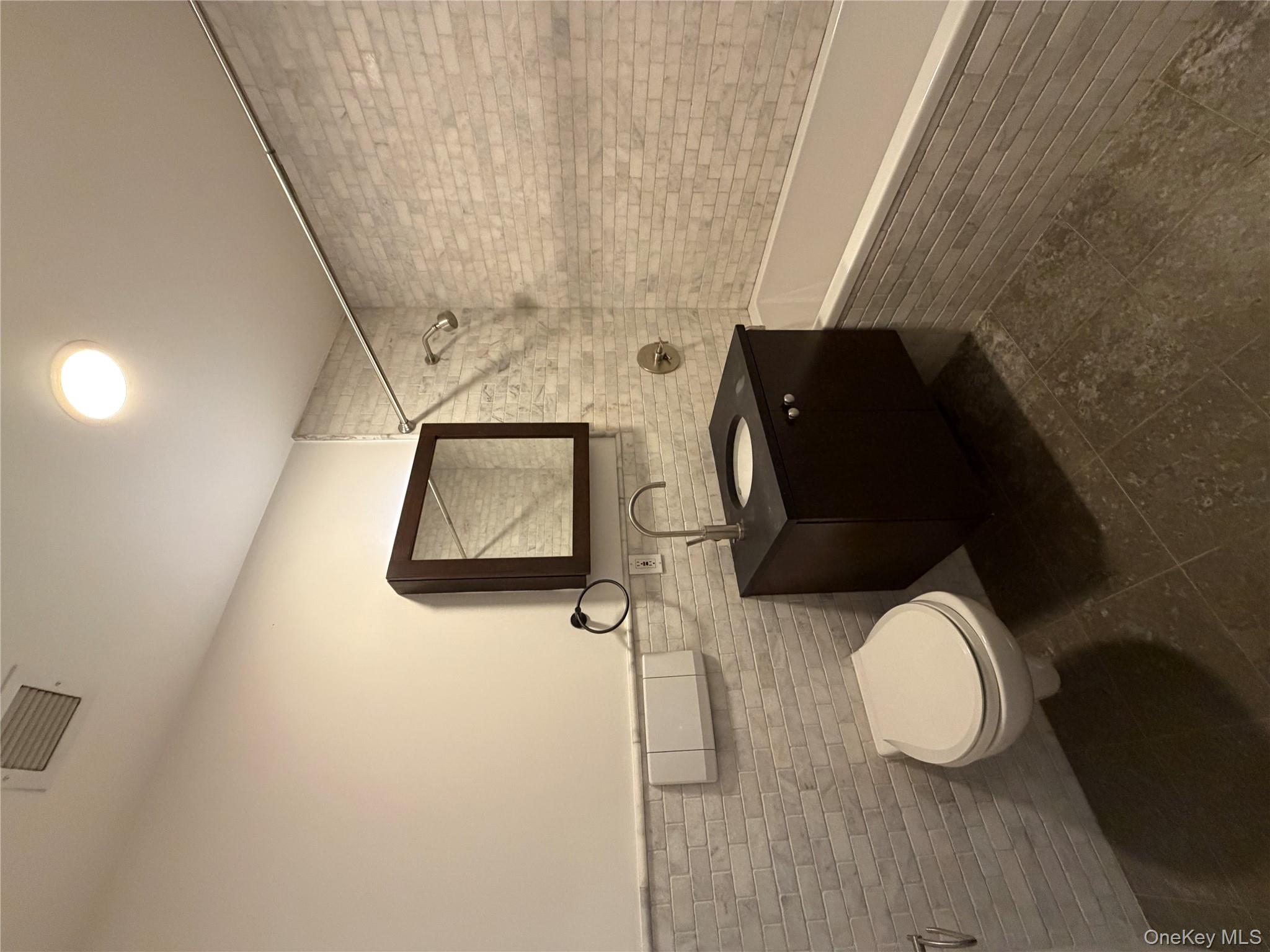 116 West 22nd Street, Unit 3 Manhattan, NY 10011 - Photo 11 of 11 Full bath featuring tile walls, vanity, tiled shower / bath, and a wainscoted wall