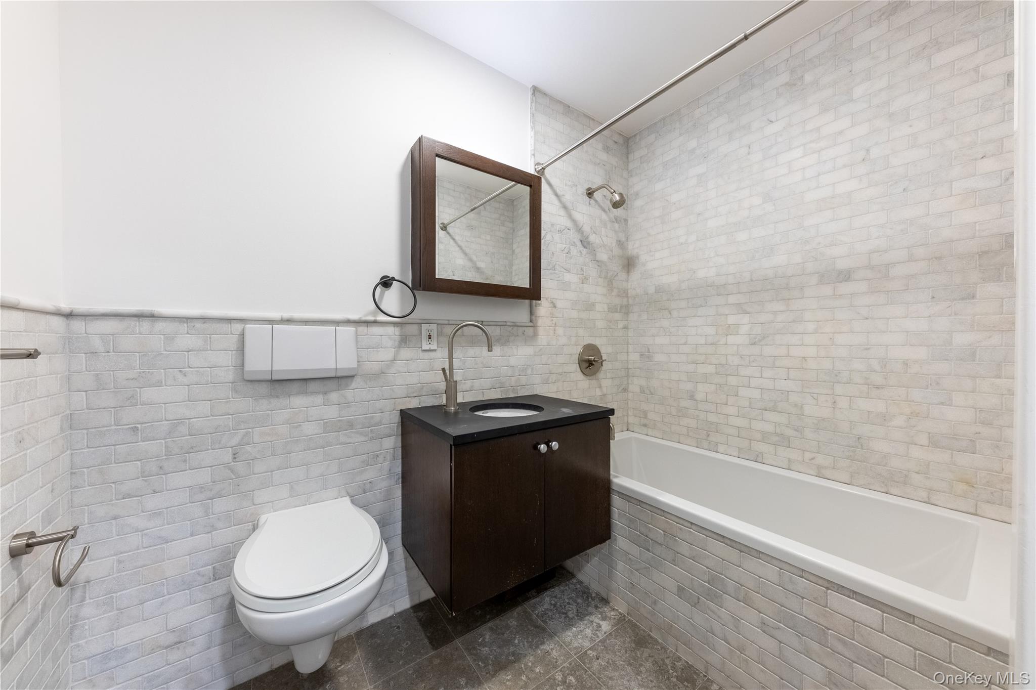 116 West 22nd Street, Unit 3 Manhattan, NY 10011 - Photo 25 of 27 a bathroom with a granite countertop toilet sink and mirror
