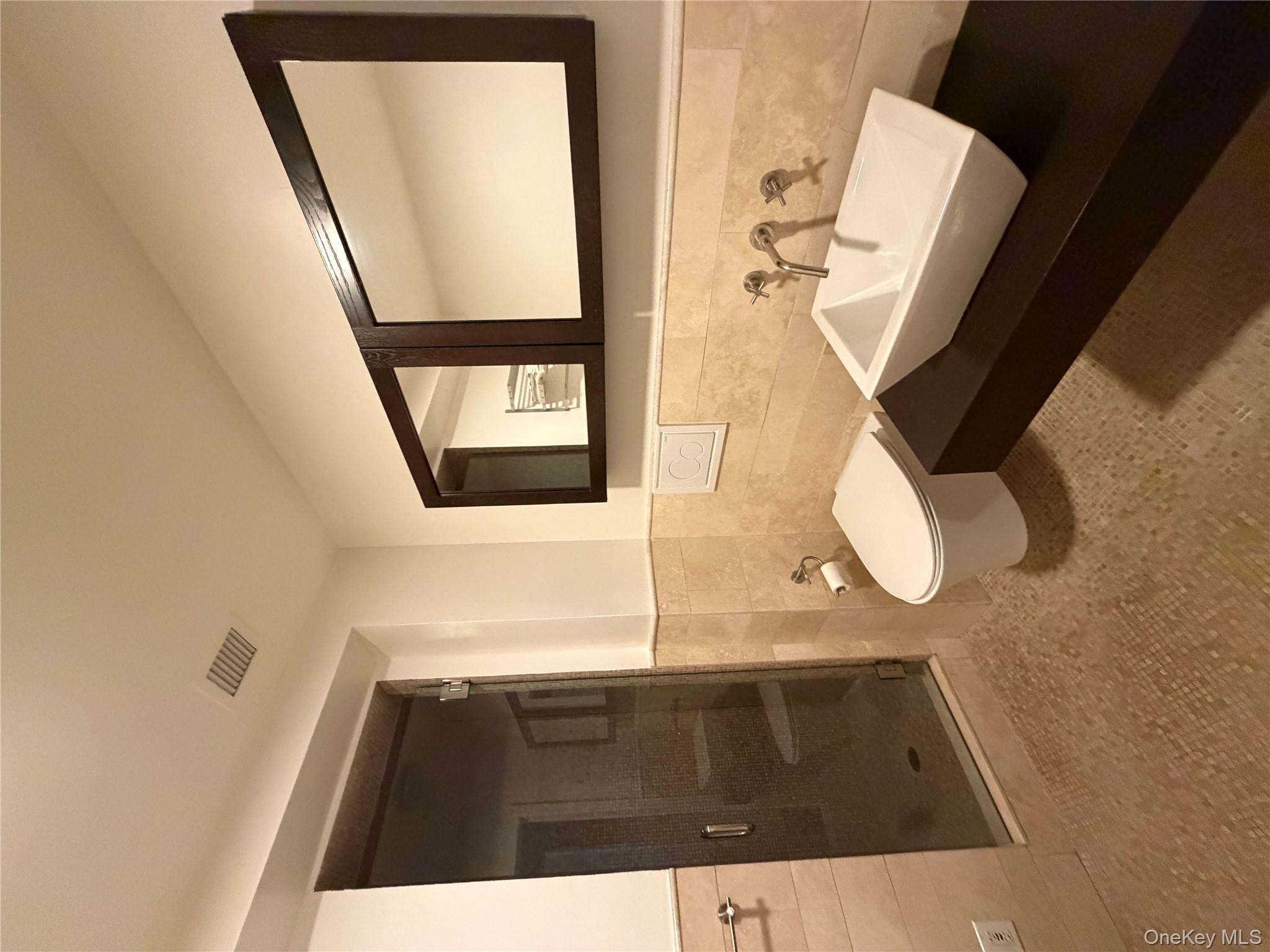 116 West 22nd Street, Unit 3 Manhattan, NY 10011 - Photo 8 of 11 Bathroom with tile walls, a wainscoted wall, a shower stall, vanity, and tile patterned flooring