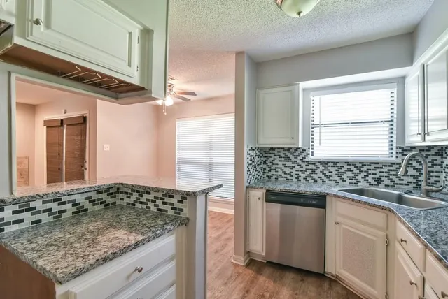 a kitchen with stainless steel appliances granite countertop a sink and a stove