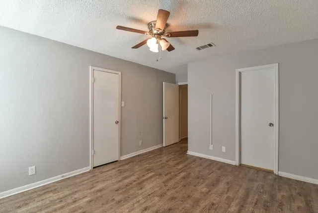 a view of an empty room with a ceiling fan
