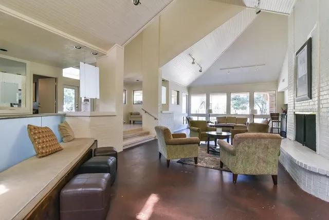 a living room with fireplace furniture and a large window