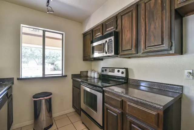 a kitchen with stainless steel appliances wooden cabinets and a stove top oven