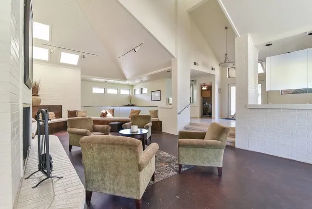 a living room with fireplace furniture and a large window
