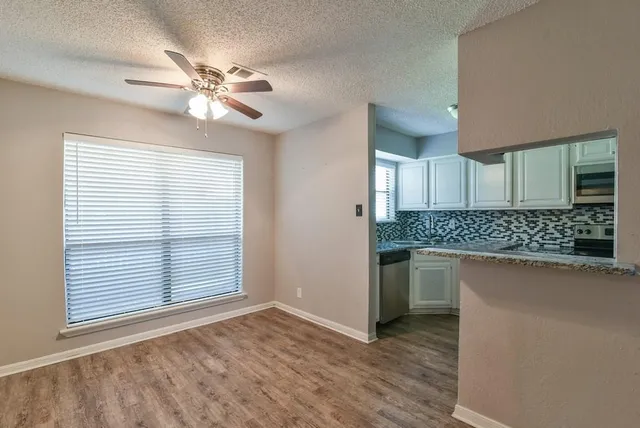 a view of a kitchen with a sink and dishwasher a kitchen island with wooden floor