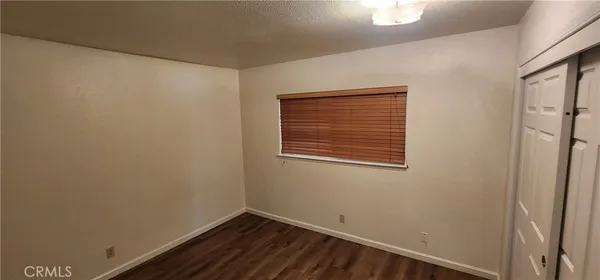 a view of a small space with wooden floor and a window