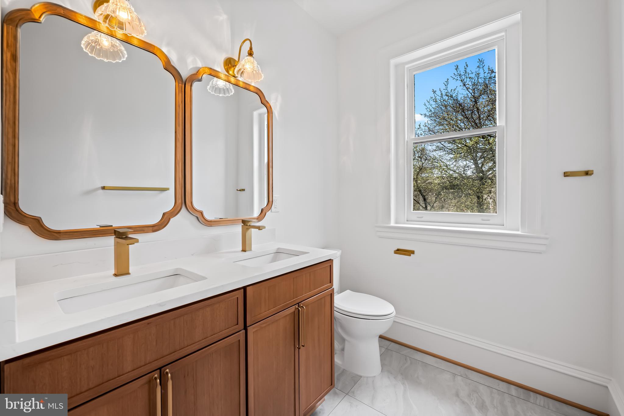 1202 Bolton Street, Unit 2 Baltimore, MD 21217 - Photo 14 of 25 a bathroom with a toilet sink and mirror