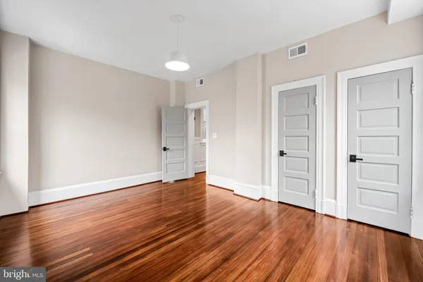 a view of an empty room with wooden floor