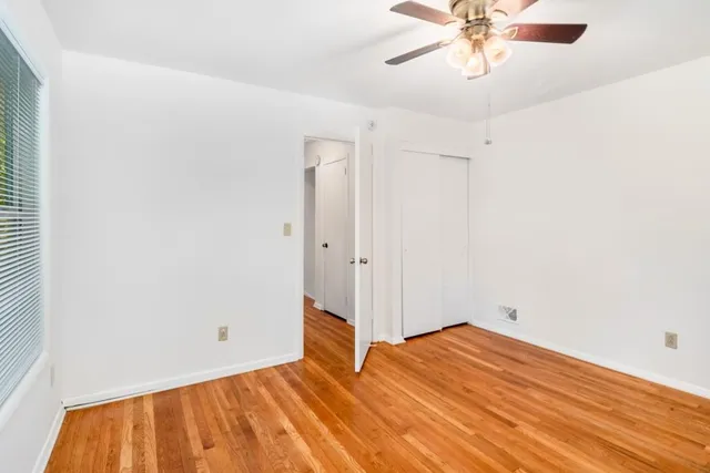 a view of empty room with wooden floor