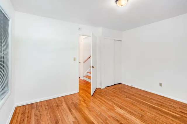 a view of empty room with wooden floor