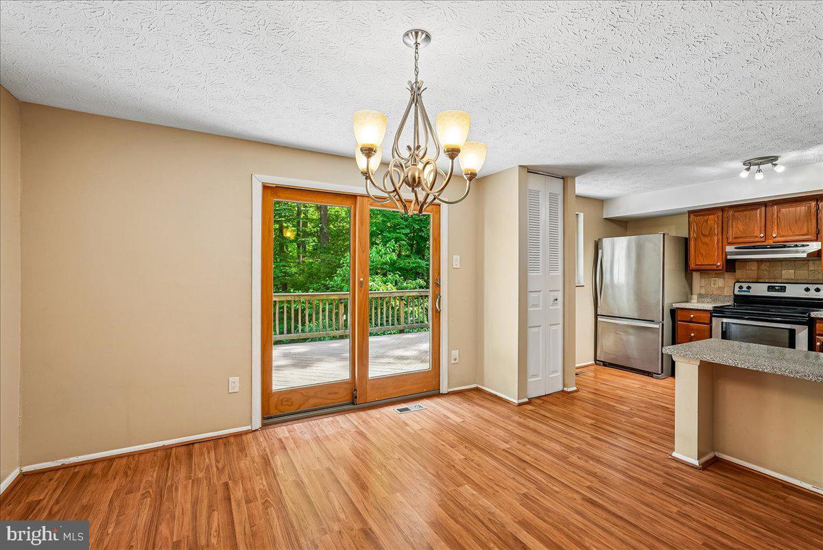 2331 Middle Creek Lane Reston, VA 20191 - Photo 17 of 78 a view of a kitchen with wooden floor a ceiling fan and windows