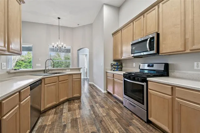 a kitchen with stainless steel appliances granite countertop a stove a sink and a microwave