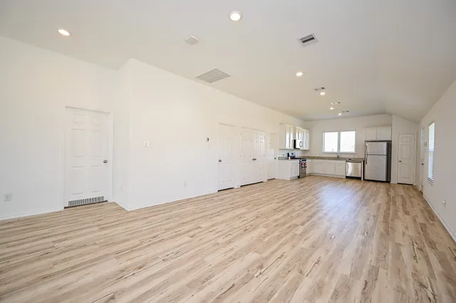 a view of empty room with wooden floor