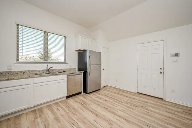 a room with a sink and a refrigerator