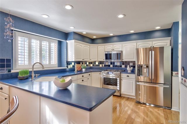 a kitchen with a refrigerator a sink a counter space and a window