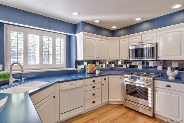 a kitchen with stainless steel appliances granite countertop a stove a sink and a microwave