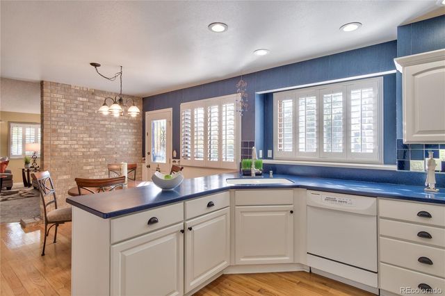 a kitchen with granite countertop white cabinets and white appliances