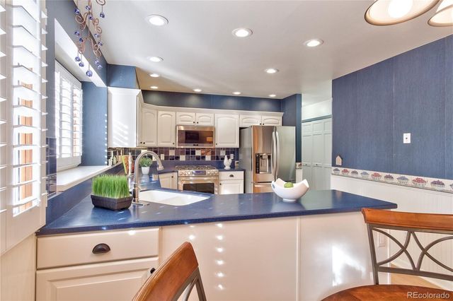 a kitchen with lots of counter top space and furniture