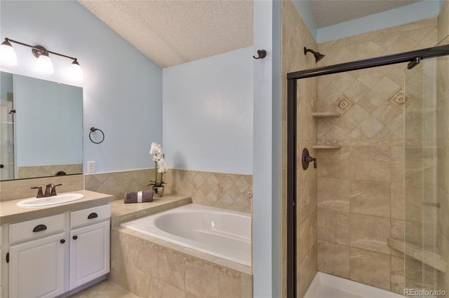 a bathroom with a tub a sink and mirror
