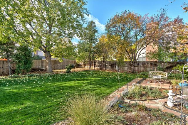 a view of backyard with swimming pool and green space
