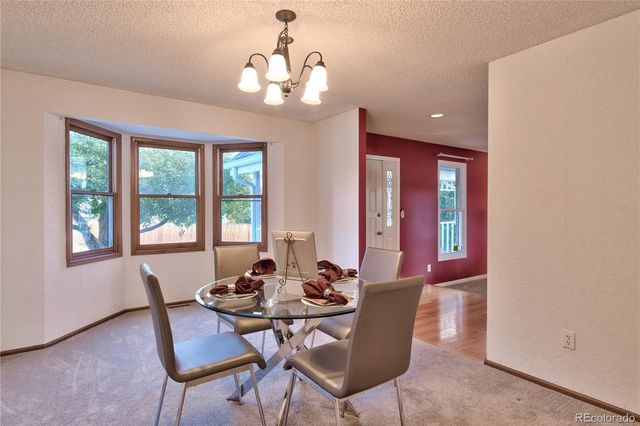a view of a dining room with furniture wooden floor and chandelier