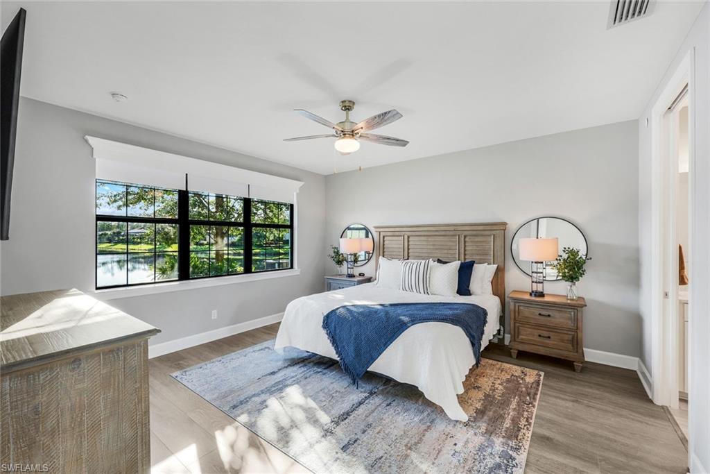 9641 Montelanico Loop, Unit 103 Naples, FL 34119 - Photo 11 of 28 a bed room with a bed and a chandelier