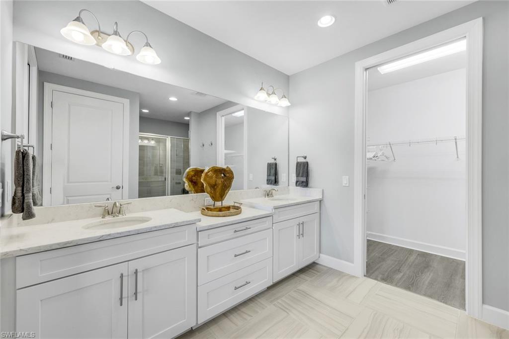 9641 Montelanico Loop, Unit 103 Naples, FL 34119 - Photo 14 of 28 a bathroom with a sink double vanity and a mirror